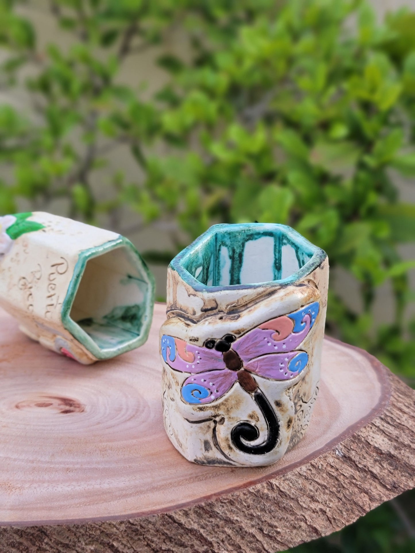 Decorative handmade ceramic dragonfly holder with a wooden surface
