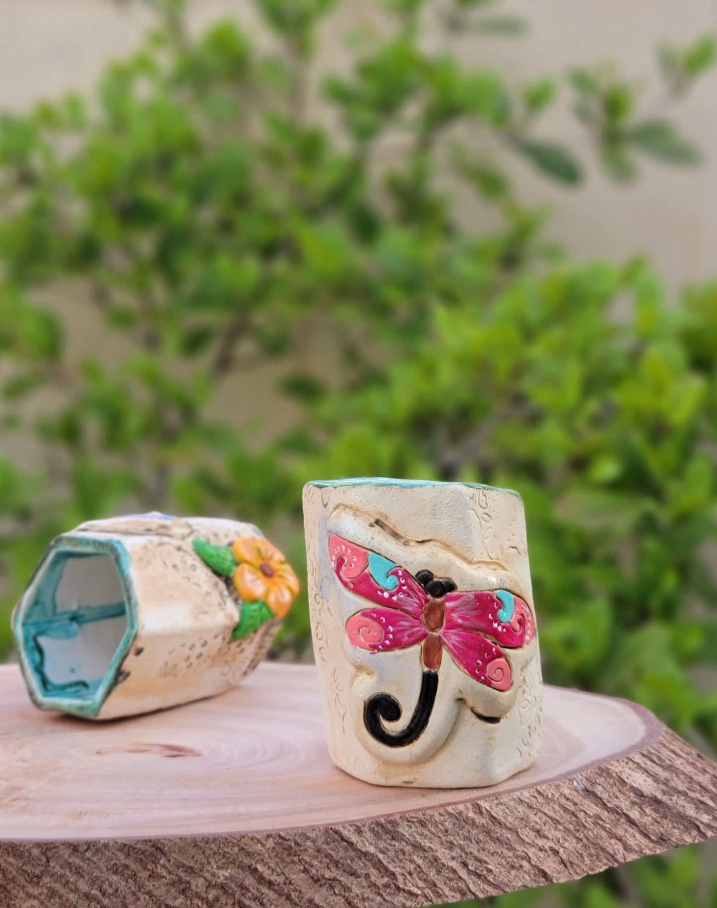 Decorative handmade ceramic dragonfly holder with a wooden surface