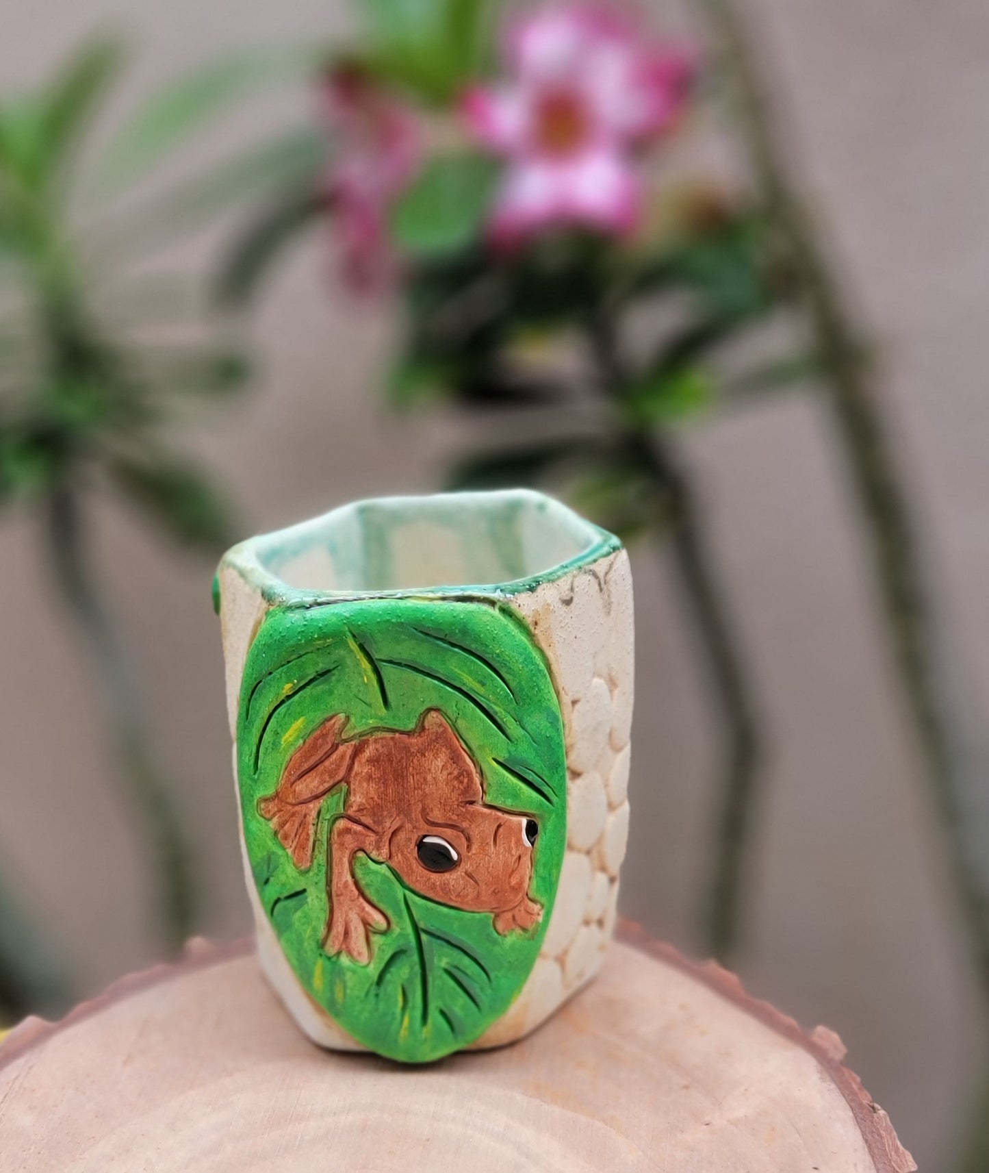 Decorative handmade ceramic Coqui frog hexagonal holder with a wooden surface