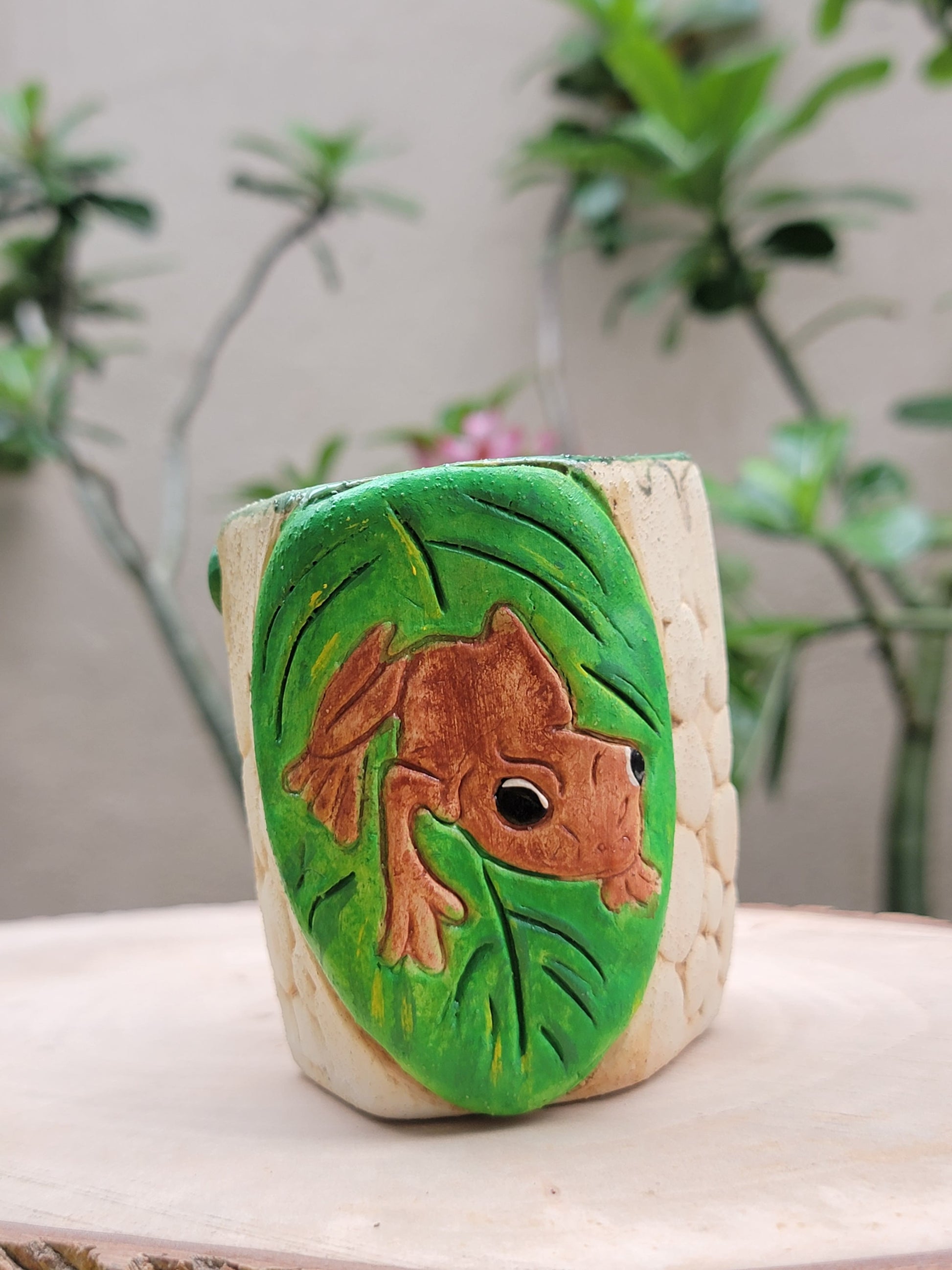 Decorative handmade ceramic Coqui frog hexagonal holder with a wooden surface