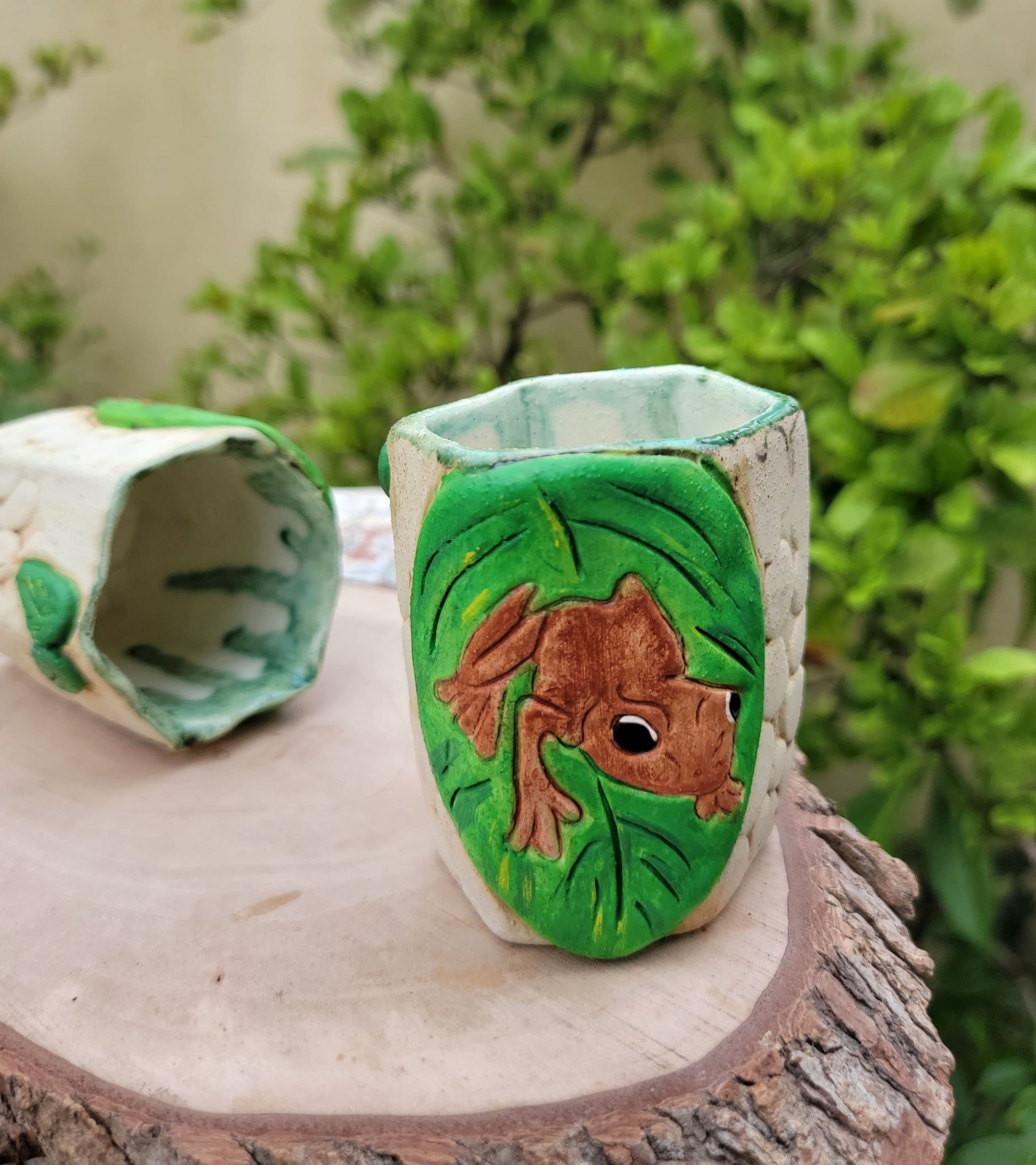 Decorative handmade ceramic Coqui frog hexagonal holder with a wooden surface