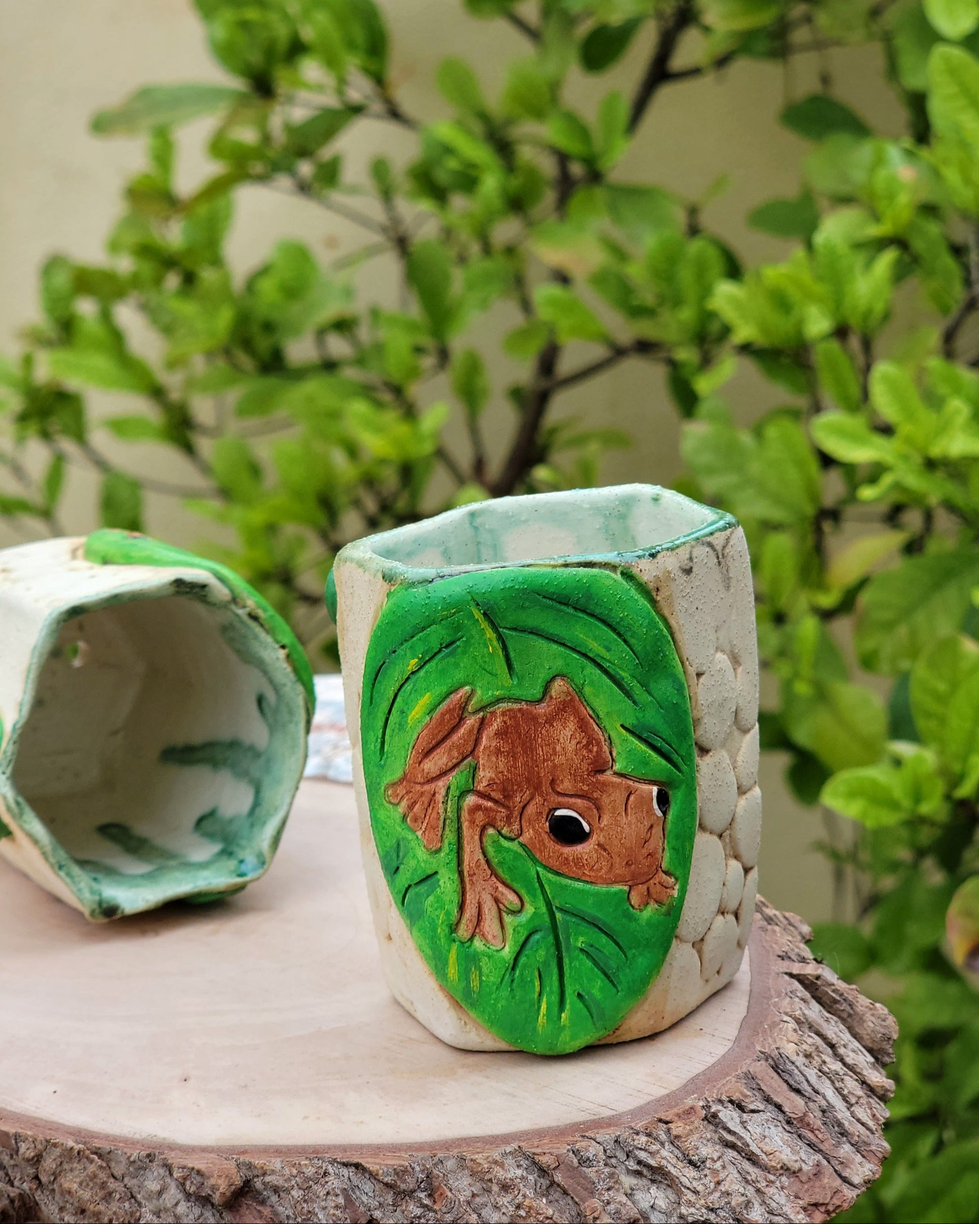 Decorative handmade ceramic Coqui frog hexagonal holder with a wooden surface