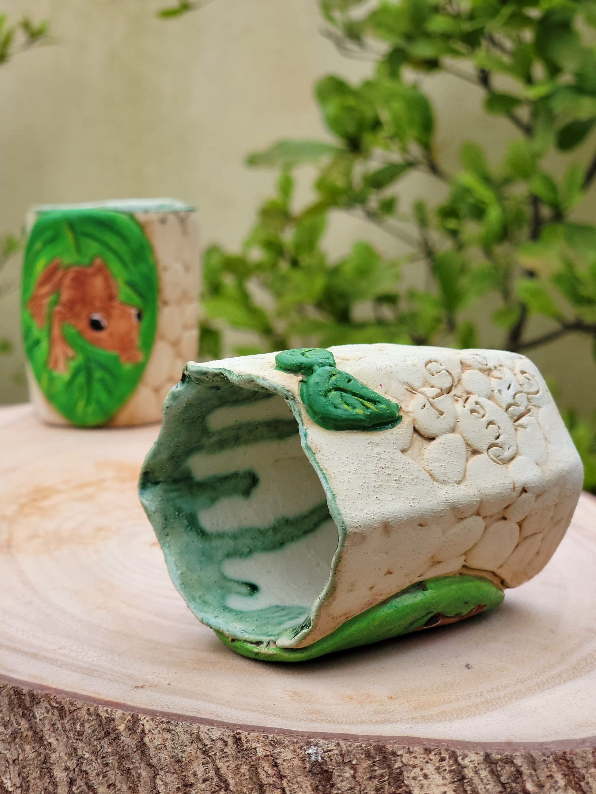 Decorative handmade ceramic Coqui frog hexagonal holder with a wooden surface