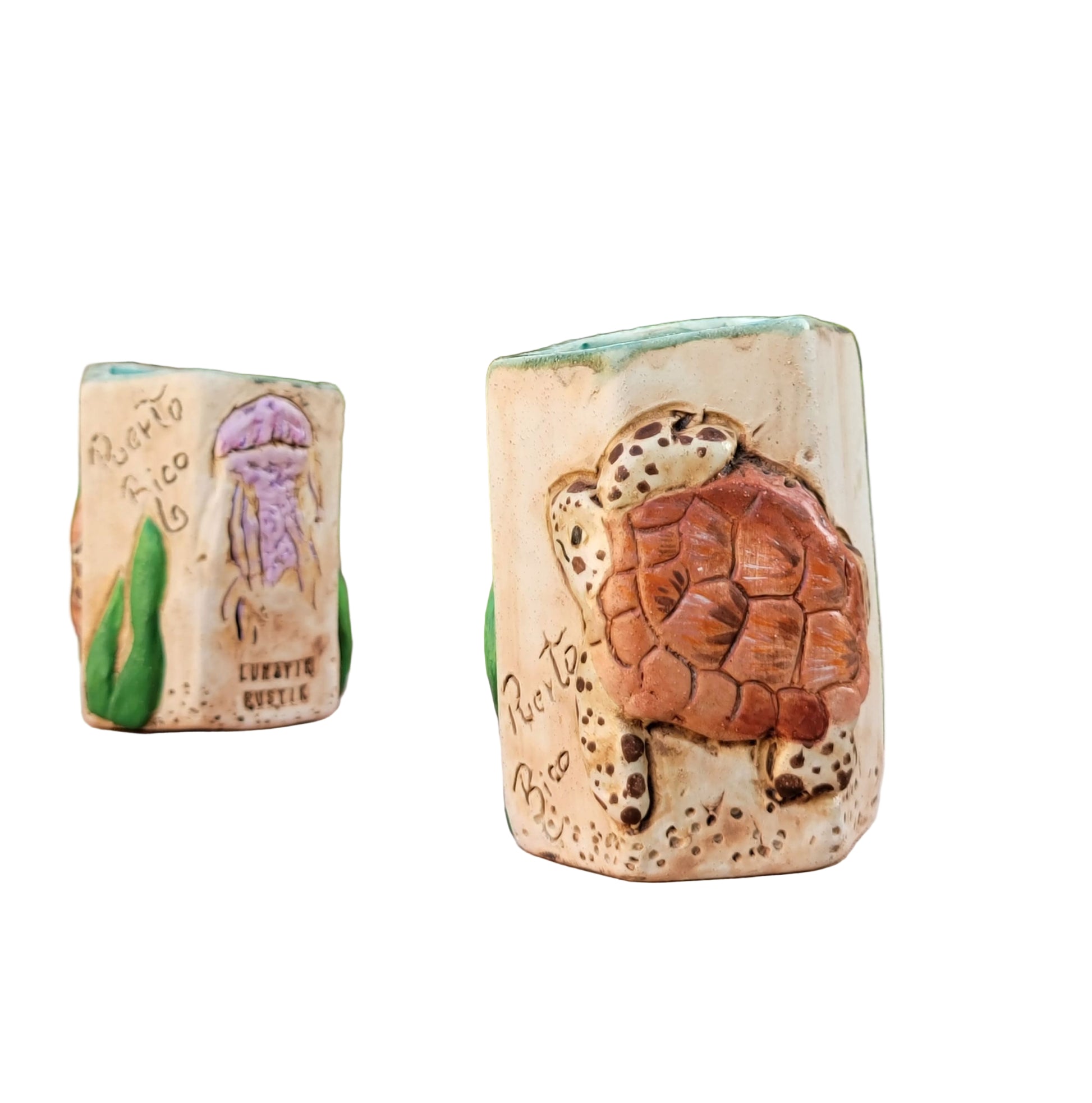 Two ceramic turtle-shaped vases on a wooden surface with a natural background