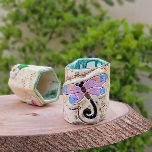 Decorative handmade ceramic dragonfly holder with a wooden surface