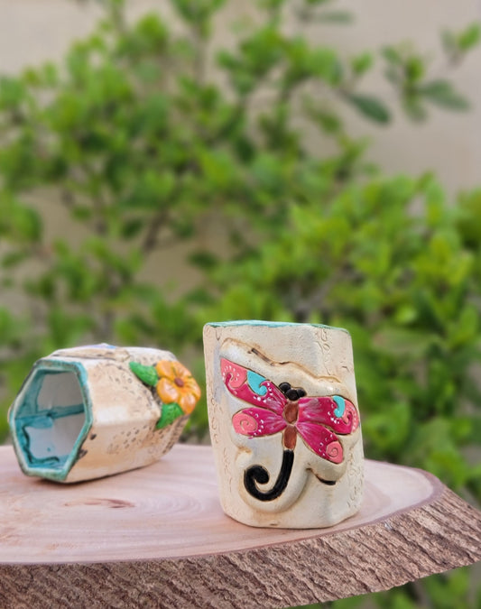Decorative handmade ceramic dragonfly holder with a wooden surface