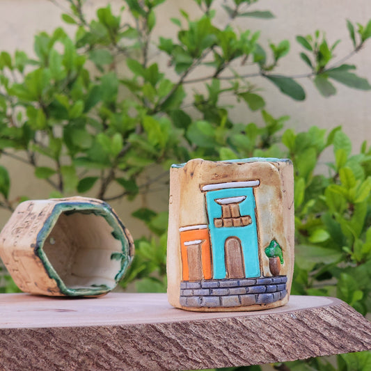 Decorative colonial facades attached to a wooden post with greenery in the background