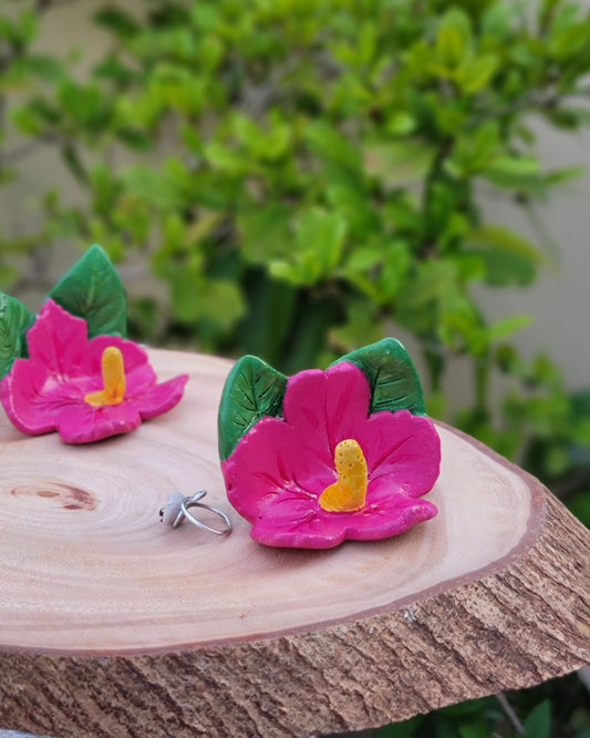 Pink flower-shaped  on a wooden block with a blurred green plant background